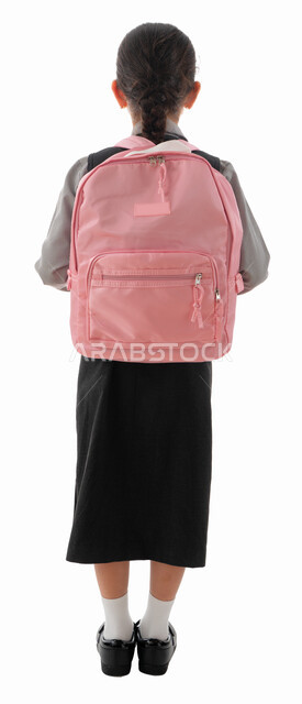 القرطاسيه والحقائب المدرسيه العصريه للبنات, بورتريه من الخلف لطالبة عربية خليجية اماراتية ترتدي المريول المدرسي وتحمل حقيبه الظهر, تلميذه سعودية مهتمه بالترتيب والمظهر الخارجي, بداية الفصل الدراسي الجديد, صوره الجسم بالطول الكامل, خلفية بيضاء.