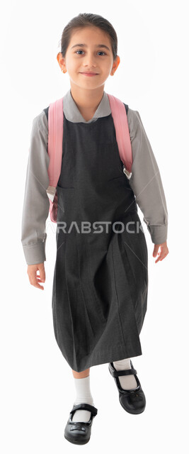 الرغبه في طلب العلم, العوده إلى المدارس والعام الدراسي الجديد, بورتريه لطالبة عربيه خليجية اماراتية ترتدي اليونيفورم وتحمل حقيبة مدرسية, طالبه سعودية تبتسم وتنظر للكاميرا, ايماءات النشاط والحيويه أثناء الذهاب للمدرسه, صورة الجسم بالطول الكامل, خلفية بيضاء