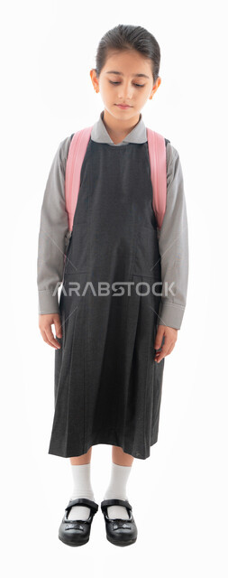 عدم الرغبة في الذهاب للمدرسة, العوده إلى المدارس وعام دراسي جديد, بورتريه لطالبة عربيه خليجية اماراتية ترتدي الزي المدرسي وتحمل الحقيبة المدرسية, تلميذه سعودية تشعر بالنعاس والإرهاق, صورة الجسم بالطول الكامل, خلفية بيضاء.