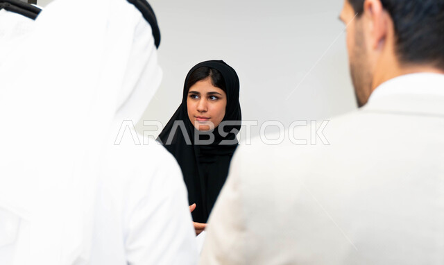 أستاذه جامعيه عربيه إماراتية خليجيه تشرح لطلابها المحاضره, مدربه جامعيه,طلاب إماراتيون يقفنا أمام الأستاذة ويتم  تدوين الملاحظات على جهاز الحاسب , التعليم الجامعي في الإمارات العربية المتحدة , فريق عمل عربي إماراتي  خليجي