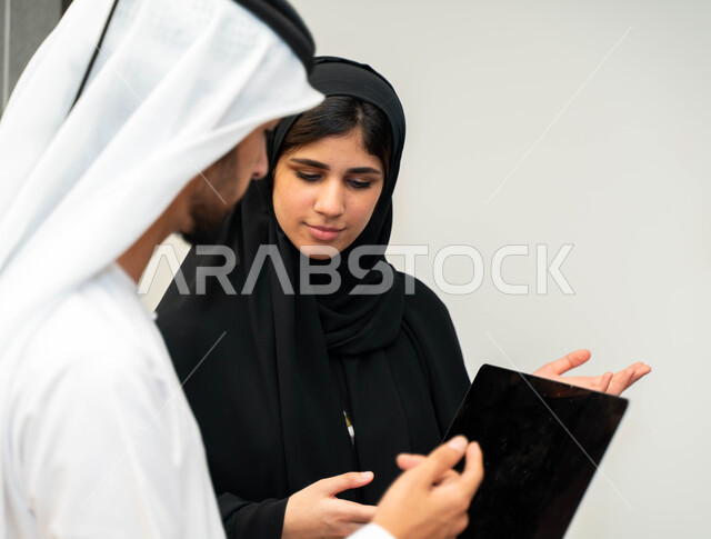 أستاذه جامعيه عربيه إماراتية خليجيه تشرح لطلابها المحاضره, مدربه جامعيه,طلاب إماراتيون يقفنا أمام الأستاذة ويتم  تدوين الملاحظات على جهاز الحاسب , التعليم الجامعي في الإمارات العربية المتحدة , فريق عمل عربي إماراتي  خليجي