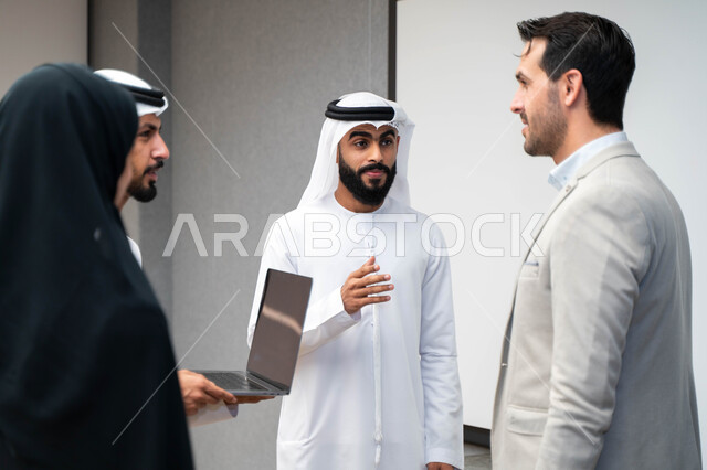 أستاذ جامعي عربي إماراتي خليجي يشرح لطلابه المحاضره, طلاب إماراتيون يقفنا أمام الاستاذ و يتم تدوين الملاحظات على جهاز الحاسب , فريق عمل عربي إماراتي  خليجي, الإجتماع في مقر العمل, مناقشة مهام العمل, تحقيق الأهداف, تدريب الموظفين, ورشة عمل