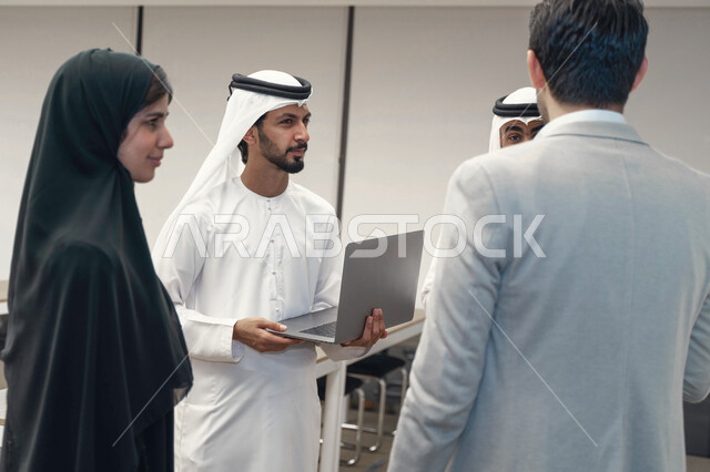 أستاذ جامعي عربي إماراتي خليجي يشرح لطلابه المحاضره, طلاب إماراتيون يقفنا أمام الاستاذ و يتم تدوين الملاحظات على جهاز الحاسب , فريق عمل عربي إماراتي  خليجي, الإجتماع في مقر العمل, مناقشة مهام العمل, تحقيق الأهداف, تدريب الموظفين, ورشة عمل