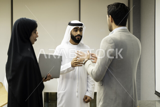 أستاذ جامعي عربي إماراتي خليجي يشرح لطلابه المحاضره, طلاب إماراتيون يقفنا أمام الاستاذ و يتم تدوين الملاحظات على جهاز الحاسب , فريق عمل عربي إماراتي  خليجي, الإجتماع في مقر العمل, مناقشة مهام العمل, تحقيق الأهداف, تدريب الموظفين, ورشة عمل