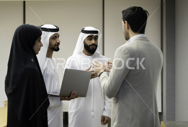 أستاذ جامعي عربي إماراتي خليجي يشرح لطلابه المحاضره, طلاب إماراتيون يقفنا أمام الاستاذ و يتم تدوين الملاحظات على جهاز الحاسب , فريق عمل عربي إماراتي  خليجي, الإجتماع في مقر العمل, مناقشة مهام العمل, تحقيق الأهداف, تدريب الموظفين, ورشة عمل