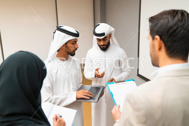 أستاذ جامعي عربي إماراتي خليجي يشرح لطلابه المحاضره, طلاب إماراتيون يقفنا أمام الاستاذ و يتم تدوين الملاحظات على جهاز الحاسب , فريق عمل عربي إماراتي  خليجي, الإجتماع في مقر العمل, مناقشة مهام العمل, تحقيق الأهداف, تدريب الموظفين, ورشة عمل