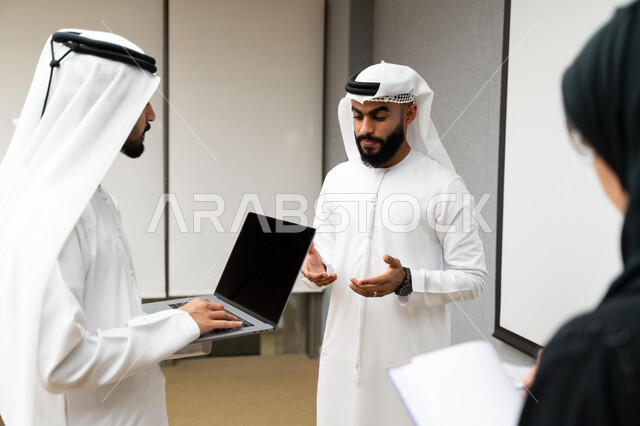 أستاذ جامعي عربي إماراتي خليجي يشرح لطلابه المحاضره, طلاب إماراتيون يقفنا أمام الاستاذ و يتم تدوين الملاحظات على جهاز الحاسب , فريق عمل عربي إماراتي  خليجي, الإجتماع في مقر العمل, مناقشة مهام العمل, تحقيق الأهداف, تدريب الموظفين, ورشة عمل