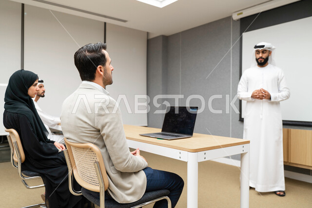 أستاذ جامعي عربي إماراتي خليجي يشرح لطلابه المحاضره, مدرب جامعي, تدوين الملاحظات على السبوره, التعليم الجامعي في الإمارات العربية المتحدة , فريق عمل عربي إماراتي خليجي, الإجتماع في مقر العمل, مناقشة مهام العمل, تحقيق الأهداف, تدريب الموظفين, ورشة عمل
