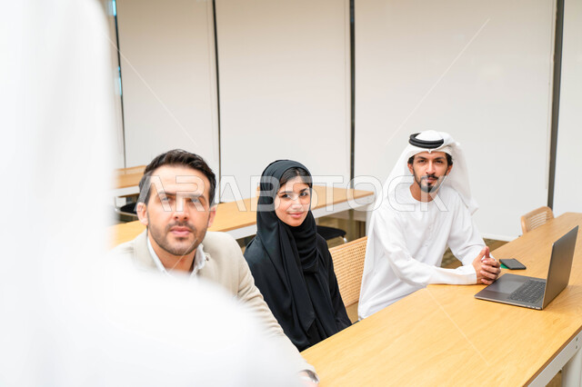 أستاذ جامعي عربي إماراتي خليجي يشرح لطلابه المحاضره, مدرب جامعي, تدوين الملاحظات على السبوره, التعليم الجامعي في الإمارات العربية المتحدة , فريق عمل عربي إماراتي خليجي, الإجتماع في مقر العمل, مناقشة مهام العمل, تحقيق الأهداف, تدريب الموظفين, ورشة عمل