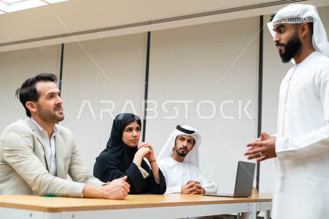 أستاذ جامعي عربي إماراتي خليجي يشرح لطلابه المحاضره, مدرب جامعي, تدوين الملاحظات على السبوره, التعليم الجامعي في الإمارات العربية المتحدة , فريق عمل عربي إماراتي خليجي, الإجتماع في مقر العمل, مناقشة مهام العمل, تحقيق الأهداف, تدريب الموظفين, ورشة عمل