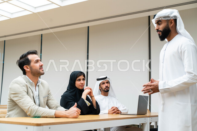 أستاذ جامعي عربي إماراتي خليجي يشرح لطلابه المحاضره, مدرب جامعي, تدوين الملاحظات على السبوره, التعليم الجامعي في الإمارات العربية المتحدة , فريق عمل عربي إماراتي خليجي, الإجتماع في مقر العمل, مناقشة مهام العمل, تحقيق الأهداف, تدريب الموظفين, ورشة عمل