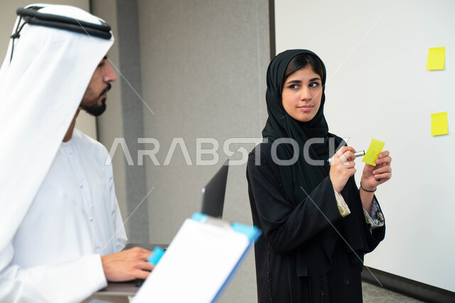 استاذة جامعيه عربيه إماراتيه خليجيه تشرح لطلابها المحاضره, مدربه جامعيه, تدوين الملاحظات على السبوره, التعليم الجامعي في الإمارات المتحدة , فريق عمل عربي إماراتي خليجي, الإجتماع في مقر العمل, مناقشة مهام العمل, تحقيق الأهداف, تدريب الموظفين, ورشة عمل