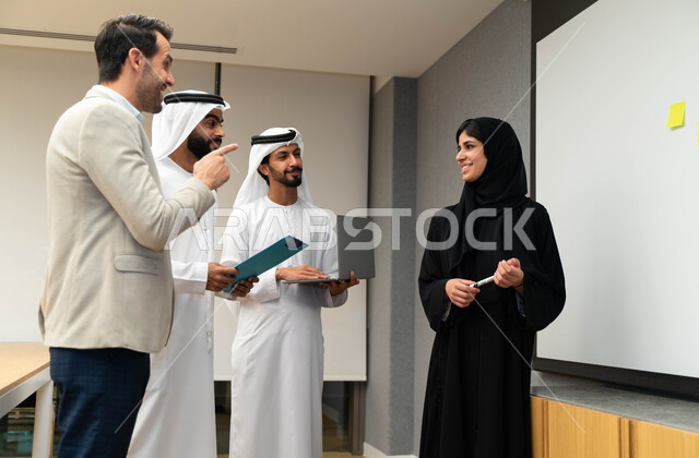 استاذة جامعيه عربيه إماراتيه خليجيه تشرح لطلابها المحاضره, مدربه جامعيه, تدوين الملاحظات على السبوره, التعليم الجامعي في الإمارات المتحدة , فريق عمل عربي إماراتي خليجي, الإجتماع في مقر العمل, مناقشة مهام العمل, تحقيق الأهداف, تدريب الموظفين, ورشة عمل