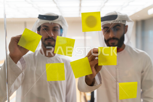 مجموعة طلاب عرب إماراتيون  خليجيون في مقر الجامعة , تدوين الملاحظات والمهام على الورق، مناقشة و تحديد الاهداف، أساتذه في الجامعه, مناقشة مشروع, التعليم الجامعي, مدربين جامعيين, وحدة العمل الجماعي, ورشة عمل