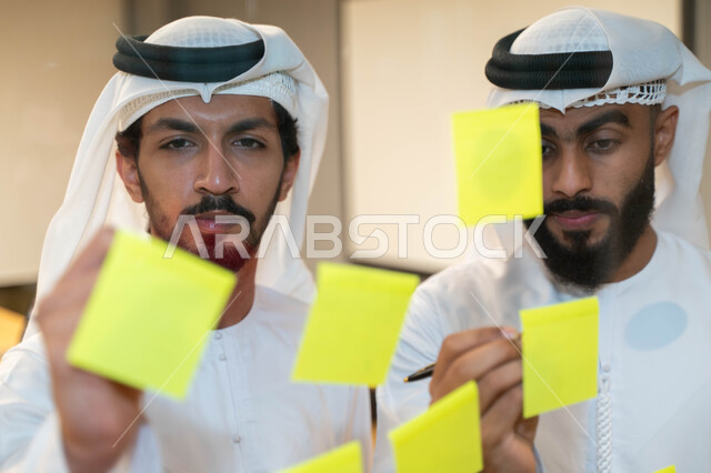 مجموعة طلاب عرب إماراتيون  خليجيون في مقر الجامعة , تدوين الملاحظات والمهام على الورق، مناقشة و تحديد الاهداف، أساتذه في الجامعه, مناقشة مشروع, التعليم الجامعي, مدربين جامعيين, وحدة العمل الجماعي, ورشة عمل