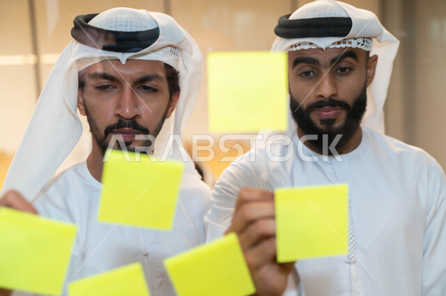 مجموعة طلاب عرب إماراتيون  خليجيون في مقر الجامعة , تدوين الملاحظات والمهام على الورق، مناقشة و تحديد الاهداف، أساتذه في الجامعه, مناقشة مشروع, التعليم الجامعي, مدربين جامعيين, وحدة العمل الجماعي, ورشة عمل