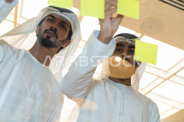 مجموعة طلاب عرب إماراتيون  خليجيون في مقر الجامعة , تدوين الملاحظات والمهام على الورق، مناقشة و تحديد الاهداف، أساتذه في الجامعه, مناقشة مشروع, التعليم الجامعي, مدربين جامعيين, وحدة العمل الجماعي, ورشة عمل