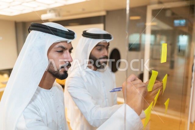 مجموعة طلاب عرب إماراتيون  خليجيون في مقر الجامعة , تدوين الملاحظات والمهام على الورق، مناقشة و تحديد الاهداف، أساتذه في الجامعه, مناقشة مشروع, التعليم الجامعي, مدربين جامعيين, وحدة العمل الجماعي, ورشة عمل