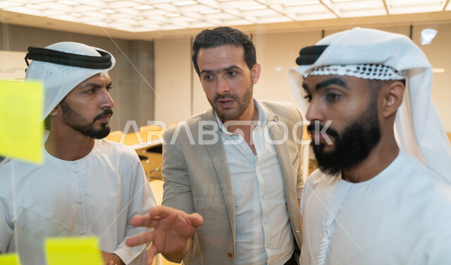 مجموعة طلاب عرب إماراتيون  خليجيون في مقر الجامعة , تدوين الملاحظات والمهام على الورق، مناقشة و تحديد الاهداف، أساتذه في الجامعه, مناقشة مشروع, التعليم الجامعي, مدربين جامعيين, وحدة العمل الجماعي, ورشة عمل