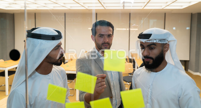 مجموعة طلاب عرب إماراتيون  خليجيون في مقر الجامعة , تدوين الملاحظات والمهام على الورق، مناقشة و تحديد الاهداف، أساتذه في الجامعه, مناقشة مشروع, التعليم الجامعي, مدربين جامعيين, وحدة العمل الجماعي, ورشة عمل