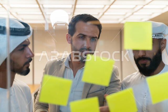 مجموعة طلاب عرب إماراتيون  خليجيون في مقر الجامعة , تدوين الملاحظات والمهام على الورق، مناقشة و تحديد الاهداف، أساتذه في الجامعه, مناقشة مشروع, التعليم الجامعي, مدربين جامعيين, وحدة العمل الجماعي, ورشة عمل