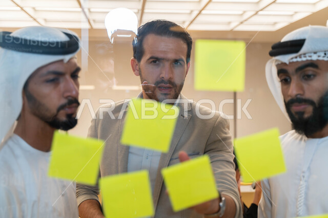 مجموعة طلاب عرب إماراتيون  خليجيون في مقر الجامعة , تدوين الملاحظات والمهام على الورق، مناقشة و تحديد الاهداف، أساتذه في الجامعه, مناقشة مشروع, التعليم الجامعي, مدربين جامعيين, وحدة العمل الجماعي, ورشة عمل