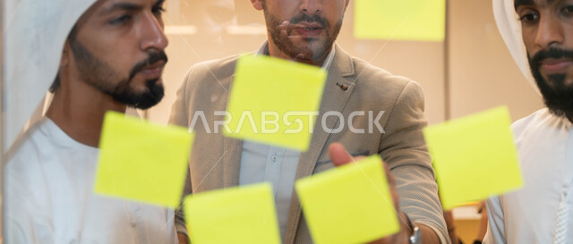 مجموعة طلاب عرب إماراتيون  خليجيون في مقر الجامعة , تدوين الملاحظات والمهام على الورق، مناقشة و تحديد الاهداف، أساتذه في الجامعه, مناقشة مشروع, التعليم الجامعي, مدربين جامعيين, وحدة العمل الجماعي, ورشة عمل