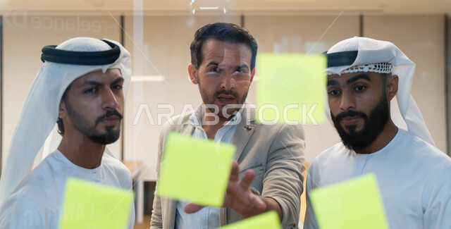 مجموعة طلاب عرب إماراتيون  خليجيون في مقر الجامعة , تدوين الملاحظات والمهام على الورق، مناقشة و تحديد الاهداف، أساتذه في الجامعه, مناقشة مشروع, التعليم الجامعي, مدربين جامعيين, وحدة العمل الجماعي, ورشة عمل