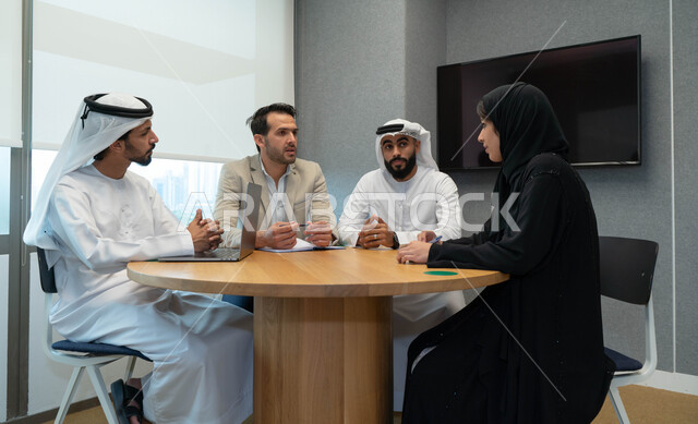 طلاب  عرب إماراتين  خليجيين في الجامعه, استاذ جامعة يناقش الطلاب المواد الدراسية , مشاركة المعلومات الدراسيه, مشروع جماعي, بحث علمي, مدربين جامعيين, اجتماع فريق عمل داخل الفصل , تحديد استراتيجيات وأهداف العمل, وحدة العمل الجماعي