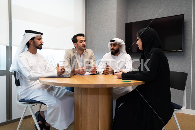 طلاب  عرب إماراتين  خليجيين في الجامعه, استاذ جامعة يناقش الطلاب المواد الدراسية , مشاركة المعلومات الدراسيه, مشروع جماعي, بحث علمي, مدربين جامعيين, اجتماع فريق عمل داخل الفصل , تحديد استراتيجيات وأهداف العمل, وحدة العمل الجماعي