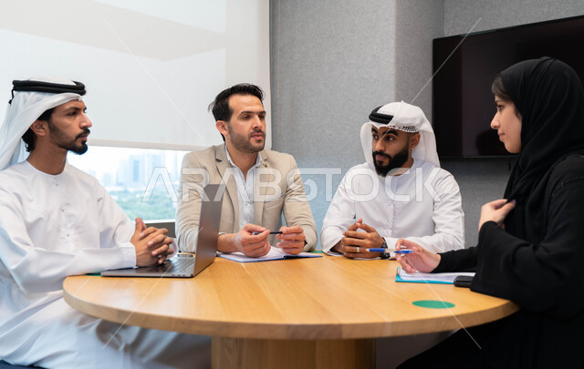 طلاب  عرب إماراتين  خليجيين في الجامعه, استاذ جامعة يناقش الطلاب المواد الدراسية , مشاركة المعلومات الدراسيه, مشروع جماعي, بحث علمي, مدربين جامعيين, اجتماع فريق عمل داخل الفصل , تحديد استراتيجيات وأهداف العمل, وحدة العمل الجماعي