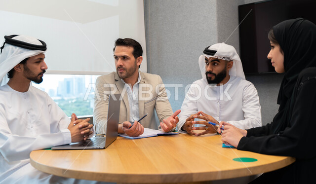 طلاب  عرب إماراتين  خليجيين في الجامعه, استاذ جامعة يناقش الطلاب المواد الدراسية , مشاركة المعلومات الدراسيه, مشروع جماعي, بحث علمي, مدربين جامعيين, اجتماع فريق عمل داخل الفصل , تحديد استراتيجيات وأهداف العمل, وحدة العمل الجماعي