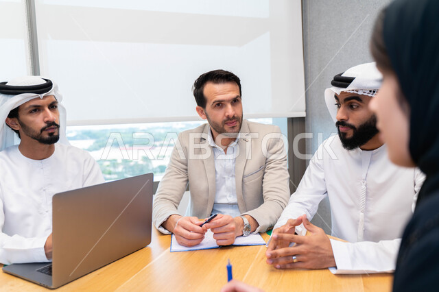 طلاب  عرب إماراتين  خليجيين في الجامعه, استاذ جامعة يناقش الطلاب المواد الدراسية , مشاركة المعلومات الدراسيه, مشروع جماعي, بحث علمي, مدربين جامعيين, اجتماع فريق عمل داخل الفصل , تحديد استراتيجيات وأهداف العمل, وحدة العمل الجماعي