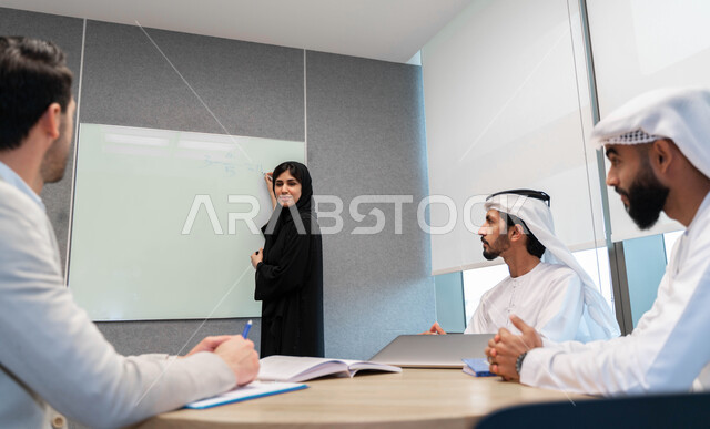 أستاذه جامعيه عربيه إماراتية خليجيه تشرح لطلابها المحاضره, مدربه جامعيه, تدوين الملاحظات على السبوره, التعليم الجامعي في الإمارات العربية المتحدة , فريق عمل عربي إماراتي  خليجي