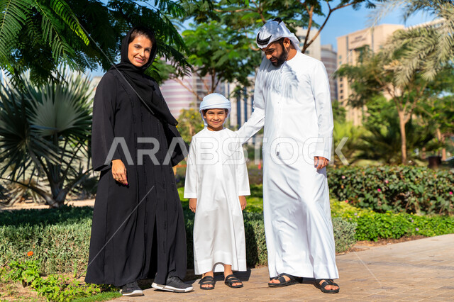 عائله عربيه إماراتية خليجيه مكونه من ثلاث أفراد, قضاء وقت ممتع في الحديقه, رحله عائليه, مفهوم الأسره السعيده, إجازه صيفيه, الاستمتاع باللعب الجماعي في المنتزه, تسليه وترفيه
