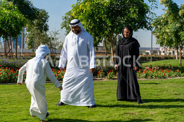 عائله عربيه إماراتية خليجيه مكونه من ثلاث أفراد, قضاء وقت ممتع في الحديقه, رحله عائليه, مفهوم الأسره السعيده, إجازه صيفيه, الاستمتاع باللعب الجماعي في المنتزه, تسليه وترفيه