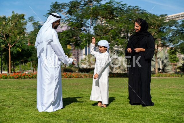 عائله عربيه إماراتية خليجيه مكونه من ثلاث أفراد, قضاء وقت ممتع في الحديقه, رحله عائليه, مفهوم الأسره السعيده, إجازه صيفيه, الاستمتاع باللعب الجماعي في المنتزه, تسليه وترفيه
