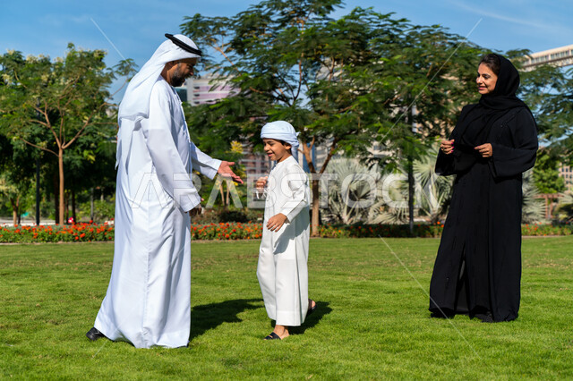 عائله عربيه إماراتية خليجيه مكونه من ثلاث أفراد, قضاء وقت ممتع في الحديقه, رحله عائليه, مفهوم الأسره السعيده, إجازه صيفيه, الاستمتاع باللعب الجماعي في المنتزه, تسليه وترفيه
