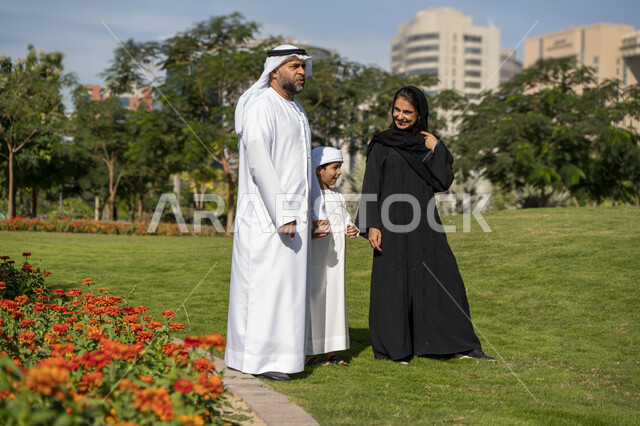 عائله عربيه إماراتية خليجيه مكونه من ثلاث أفراد, قضاء وقت ممتع في الحديقه, رحله عائليه, مفهوم الأسره السعيده, إجازه صيفيه, الاستمتاع باللعب الجماعي في المنتزه, تسليه وترفيه
