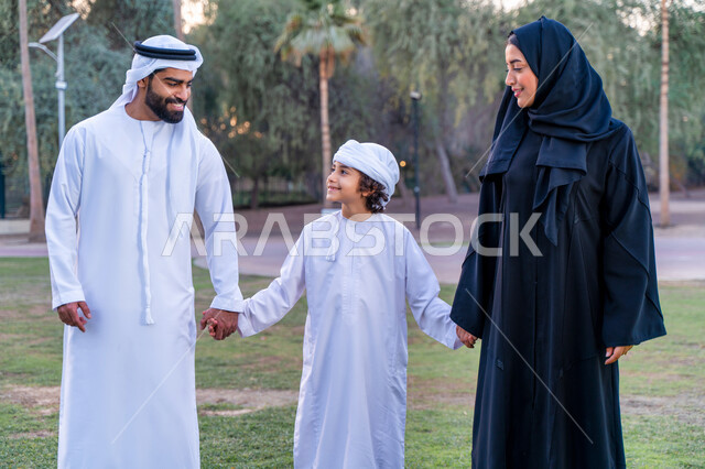 عائله عربيه إماراتيه  خليجيه مكونه من ثلاث أفراد, قضاء وقت ممتع في الحديقه, رحله عائليه عند غروب الشمس , مفهوم الأسره السعيده, إجازه صيفيه, الاستمتاع باللعب الجماعي في المنتزه, تسليه وترفيه, عطلة نهاية الاسبوع