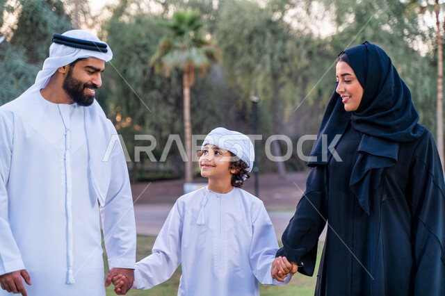 عائله عربيه إماراتيه  خليجيه مكونه من ثلاث أفراد, قضاء وقت ممتع في الحديقه, رحله عائليه عند غروب الشمس , مفهوم الأسره السعيده, إجازه صيفيه, الاستمتاع باللعب الجماعي في المنتزه, تسليه وترفيه, عطلة نهاية الاسبوع