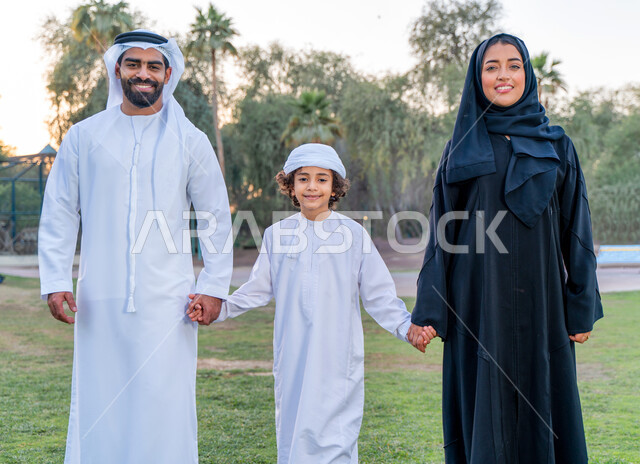 عائله عربيه إماراتيه  خليجيه مكونه من ثلاث أفراد, قضاء وقت ممتع في الحديقه, رحله عائليه عند غروب الشمس , مفهوم الأسره السعيده, إجازه صيفيه, الاستمتاع باللعب الجماعي في المنتزه, تسليه وترفيه, عطلة نهاية الاسبوع