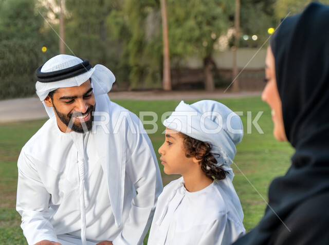 عائله عربيه إماراتيه  خليجيه مكونه من ثلاث أفراد, قضاء وقت ممتع في الحديقه, ايماءات وجه تدل على السعادة , النظر الى بعضهم البعض بكل حب ,  رحله عائليه في يوم مشمس, مفهوم الأسره السعيده, إجازه صيفيه, الاستمتاع باللعب الجماعي في المنتزه, تسليه وترفيه, عطلة ن