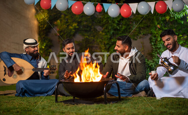 مجموعة من الشباب العرب الخليجيين السعوديين يقضون أوقات ممتعة في إحدى الشاليهات السياحية بالسعودية، فعاليات شبابية ترفيهية، شاب يقوم بصب القهوة واخر يعزف على آلة العود، أجواء شتوية، جلسة وناسة وتعارف، إجتماع الأصدقاء، سهرة شبابية