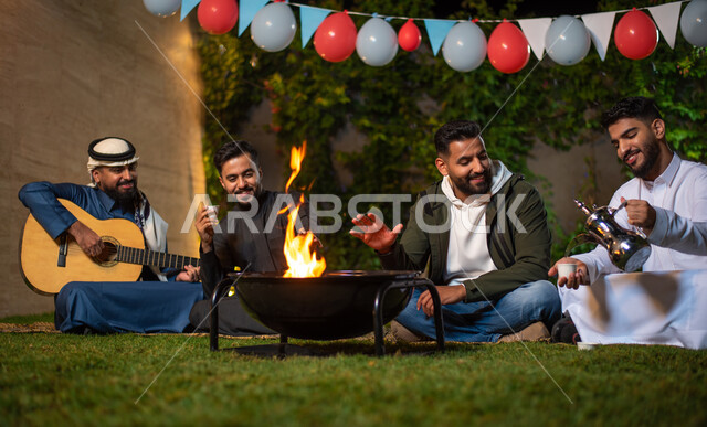 مجموعة من الشباب العرب الخليجيين السعوديين يقضون أوقات ممتعة في إحدى الشاليهات السياحية بالسعودية، فعاليات شبابية ترفيهية، شاب يقوم بصب القهوة واخر يعزف على آلة القيثارة، أجواء شتوية، جلسة وناسة وتعارف، إجتماع الأصدقاء، سهرة شبابية