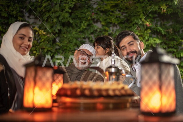 عائلة عربية خليجية سعودية، تنظر إلى الكاميرا، تقضي أوقات ممتعة في إحدى الشاليهات السياحية بالسعودية، فعاليات ترفيهية عائلية، أجواء عائلية سعيدة، أجواء شتوية، منتجعات وشاليهات ترفيهية بالسعودية، سهرة عائلية، إجتماع الأهل
