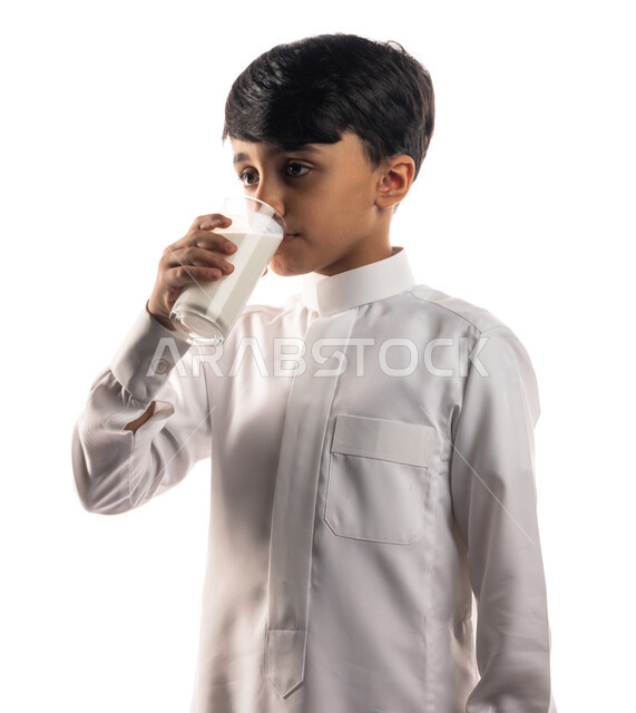 بورتريه لولد عربي خليجي سعودي ،  يقوم بشرب الحليب ، فطور صحي ، مفهوم الصحة ، مشروب صحي ، إتباع نظام غذائي صحي ، خلفية بيضاء