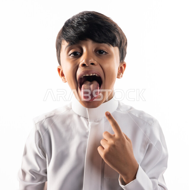 بورتريه لولد عربي خليجي سعودي ، يشير إصبعه السبابة على لسانه ، سلامة وصحة اللسان ، خلفية بيضاء