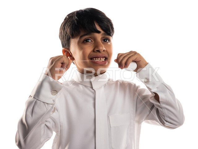 بورتريه لولد عربي خليجي سعودي ، يقوم بإستخدام خيط تنظيف الأسنان ، مفهوم العناية والإهتمام بصحة الأسنان ، معدات طب الأسنان ، نظافة الأسنان ، خلفية بيضاء