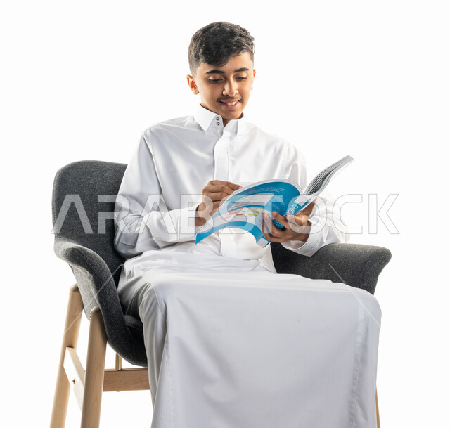 بورتريه لولد عربي سعودي خليجي، يجلس على كرسي، تأدية الواجبات المدرسية، مراجعة الدروس، الإستعداد للعام الدراسي الجديد، التعليم الدراسي في السعودية ، العودة إلى المدارس، المذاكرة للإختبارات المدرسية، خلفية بيضاء